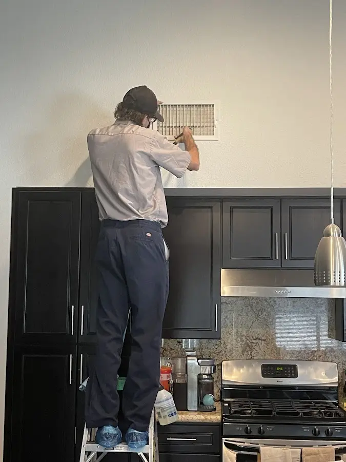 Technician inspecting an air vent during HVAC service in Lake Wylie
